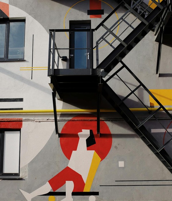 Vivid urban mural featuring geometric shapes and an exterior staircase, showcasing modern artistic flair.